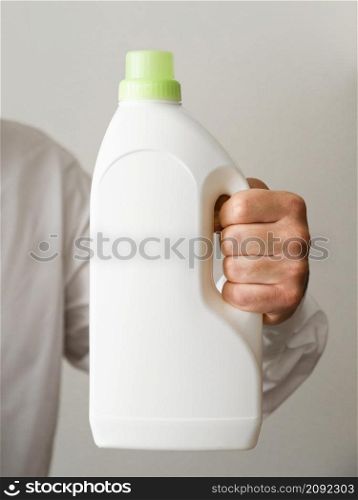 OLYMPUS DIGITAL CAMERA. close up hand holding detergent bottle mock up
