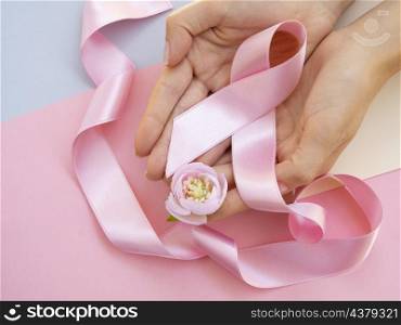 OLYMPUS DIGITAL CAMERA. close up person with pink ribbon top view