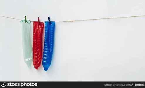 OLYMPUS DIGITAL CAMERA. colourful condoms clothesline with white background