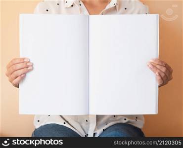 OLYMPUS DIGITAL CAMERA. front view woman holding mock up magazine