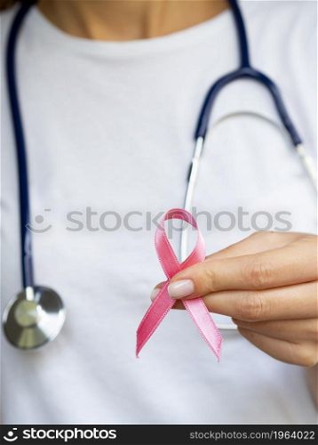 OLYMPUS DIGITAL CAMERA. High resolution photo. close up girl with pink ribbon stethoscope. High quality photo