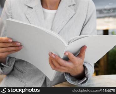 OLYMPUS DIGITAL CAMERA. High resolution photo. close up woman reading mock up magazine. High quality photo