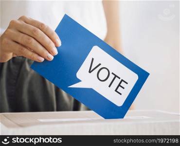 OLYMPUS DIGITAL CAMERA. High resolution photo. front view woman putting voting message box close up. High quality photo