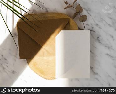 OLYMPUS DIGITAL CAMERA. High resolution photo. marble background with wooden plate with brown envelope white blank. High quality photo