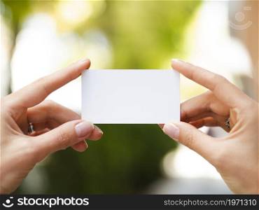 OLYMPUS DIGITAL CAMERA. High resolution photo. woman holding up business card mock up. High quality photo