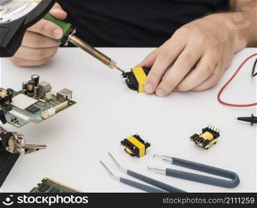 OLYMPUS DIGITAL CAMERA. man fixing connector using soldering iron