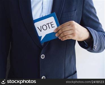 OLYMPUS DIGITAL CAMERA. man getting voting card from his jacket