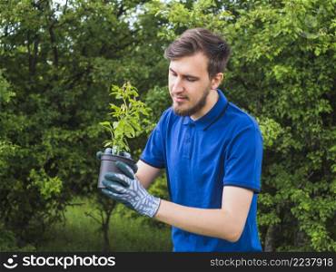 OLYMPUS DIGITAL CAMERA. man planting small plant pot