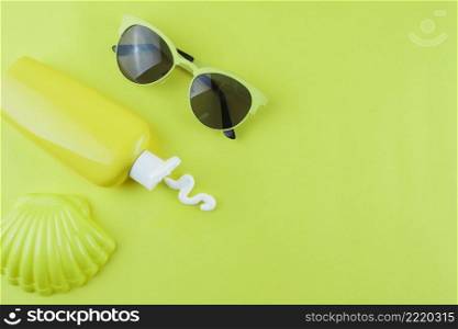 OLYMPUS DIGITAL CAMERA. plastic scallop sunscreen lotion sunglasses green background