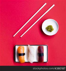 OLYMPUS DIGITAL CAMERA. sushi plate with wasabi chop sticks red background
