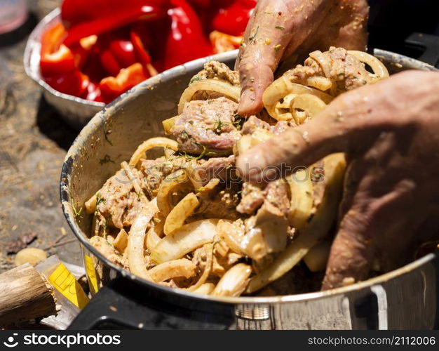 OLYMPUS DIGITAL CAMERA. unrecognizable cook mixing pieces meat onion shashlik