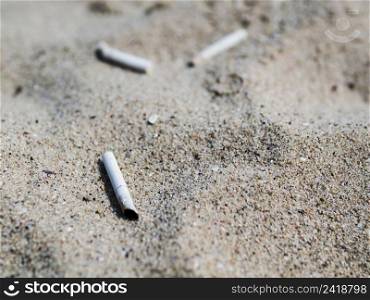 OLYMPUS DIGITAL CAMERA. used cigarette butts sand beach