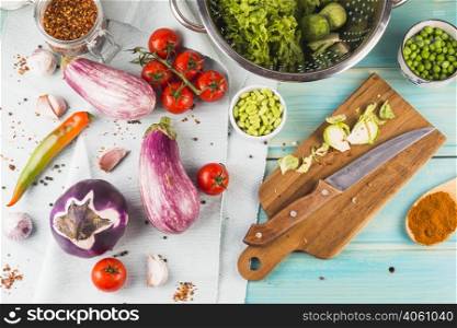 OLYMPUS DIGITAL CAMERA. vegetables spices with chopping board knife wooden table