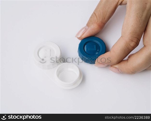 OLYMPUS DIGITAL CAMERA. woman opening contact lenses box