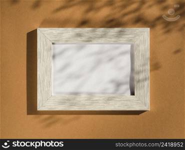 OLYMPUS DIGITAL CAMERA. wooden portrait frame beige background covered with leaf shadows