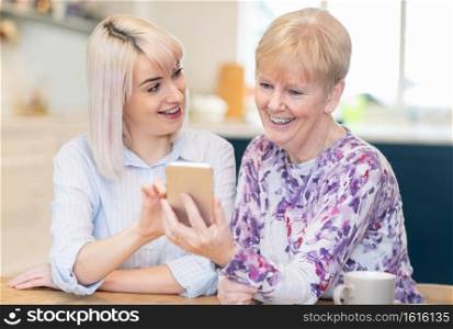 oman Helping Senior Neighbor Expaining How To Use Mobile Phone