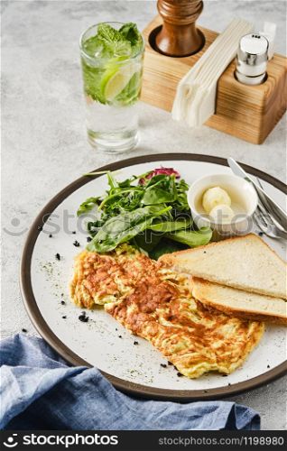 Omelet with herbs, bread and butter. Healthy breakfast.