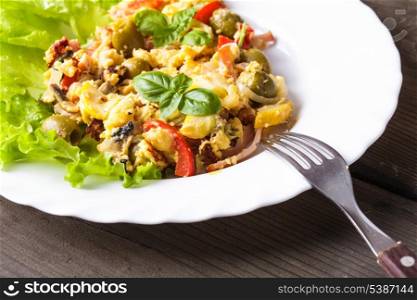 Omelet with vegetables and bacon on the plate