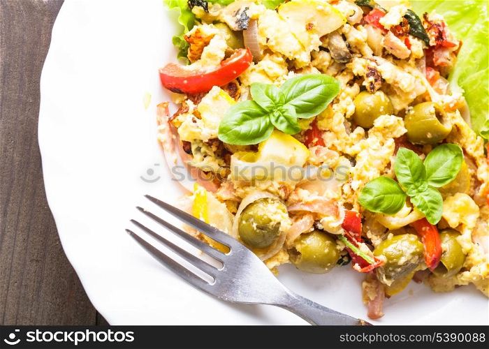 Omelet with vegetables and bacon on the plate