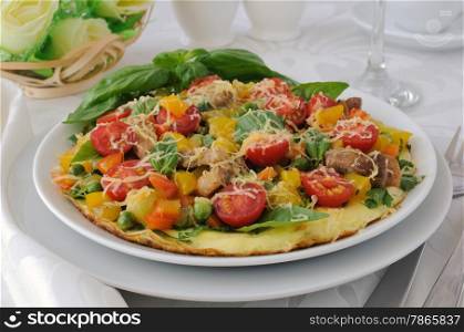 Omelet with vegetables and slices of bacon and cheese with basil
