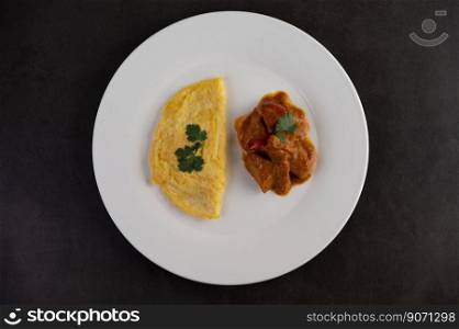 Omelette and Massaman placed on a plate on a white background.