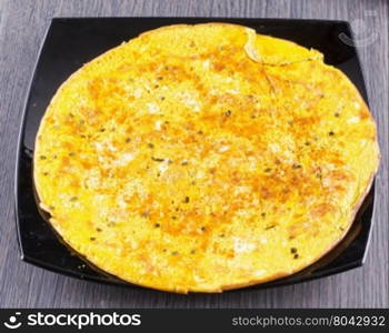 Omelette over black reflecting plate, horizontal image