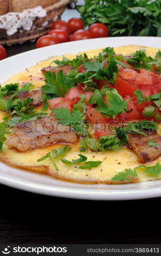 Omelette slices of fried bacon, tomatoes with herbs