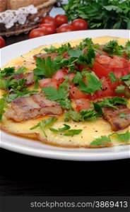 Omelette slices of fried bacon, tomatoes with herbs