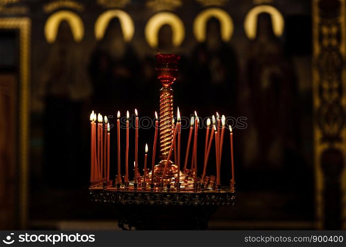 On a large Church copper candlestick lit a small candle. Religion. Orthodox Christian Church.. On a large Church copper candlestick lit a small candle. Orthodox Christian Church. Religion