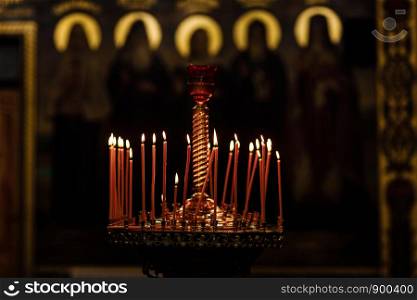On a large Church copper candlestick lit a small candle. Religion. Orthodox Christian Church.. On a large Church copper candlestick lit a small candle. Orthodox Christian Church. Religion