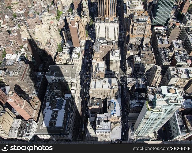 On a sunny day, the shadow of the Empire State building extends over blocks of buildings throughout midtown Manhattan in New York City.