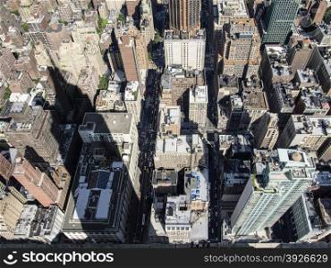 On a sunny day, the shadow of the Empire State building extends over blocks of buildings throughout midtown Manhattan in New York City.