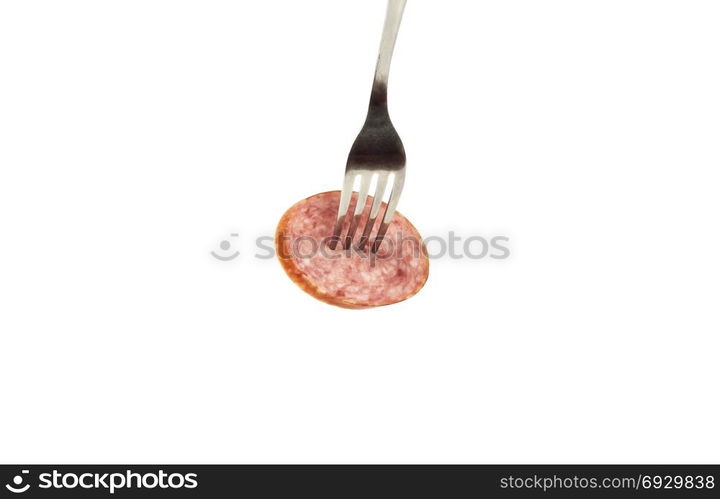 On a white background a piece of sausage is pinned on a metal fork