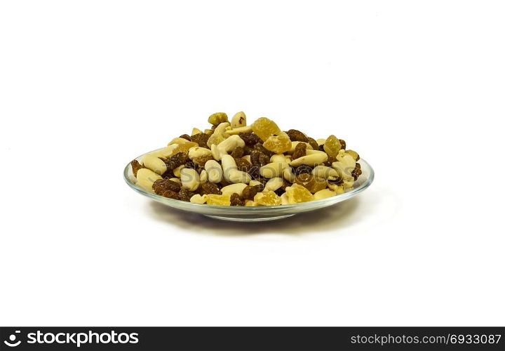 On a white background there is a glass saucer with a mixture of nuts, raisins and candied fruits