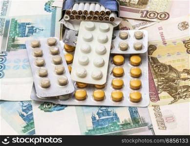 On banknotes is a pack of cigarettes and packaging of medical drugs
