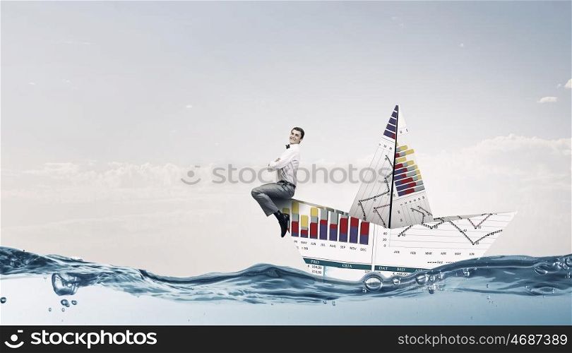 On board of paper ship. Businessman floating in boat made of paper