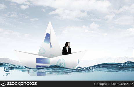 On board of paper ship. Businesswoman floating in boat made of paper