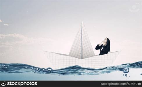 On board of paper ship. Businesswoman floating in boat made of paper