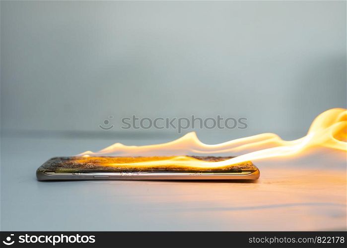 On fire smart phone screen is cracked with blurred background