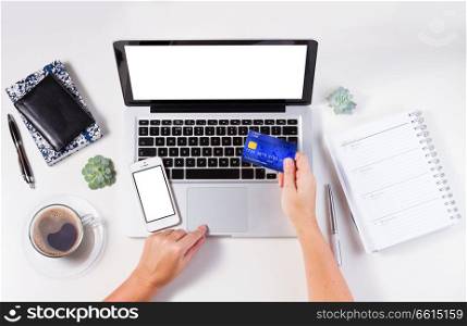 On-line shopping concept - desktop with laptop and hands holging credit card. On-line shopping concept