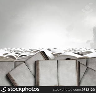 On pile of books. Top view of female legs in sport shoes standing on pile of books