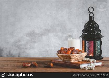 On table top image of decorations Ramadan Kareem holiday background.Close up Arabic lantern metal date and milk on brown wooden.Halal meal set for fasting is obligatory for Muslim.copy space design.