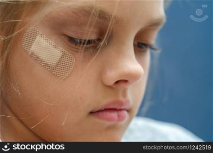 On the girl&rsquo;s face is glued Band-Aid, close-up