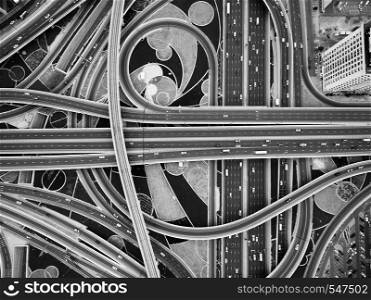 On the road going trucks, cars, trains. aerial view of road junction with railway tracks in Dubai, UAE