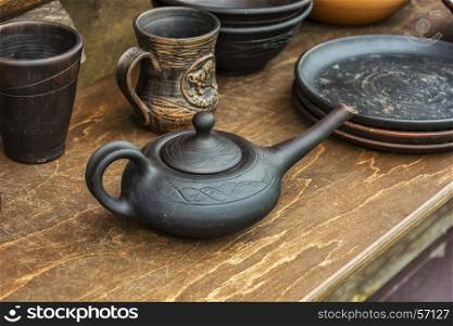 On the wooden table is ceramic hand-made pottery
