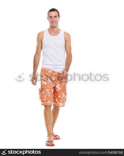 On vacation smiling young man in shorts walking