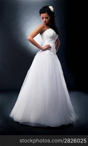 One beautiful fiancee in marital white dress posing in studio - series of photos