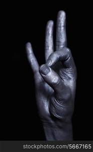 One beautiful male hand in silver paint on a black background