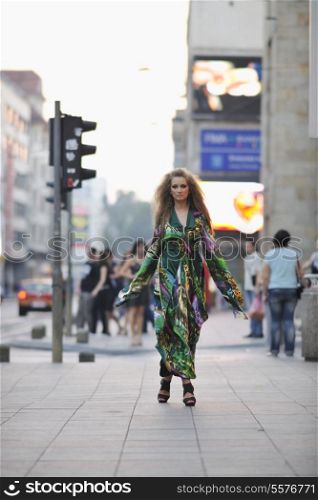 one beautiful young elegant woman in fashion and urban style dress in city on street at night alone