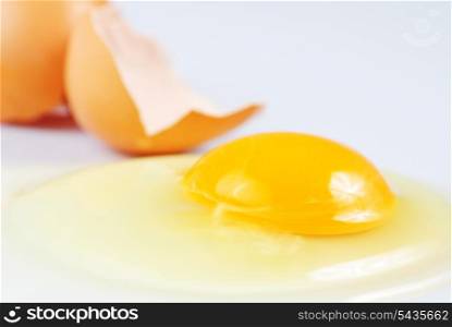 One beige cracked egg on white